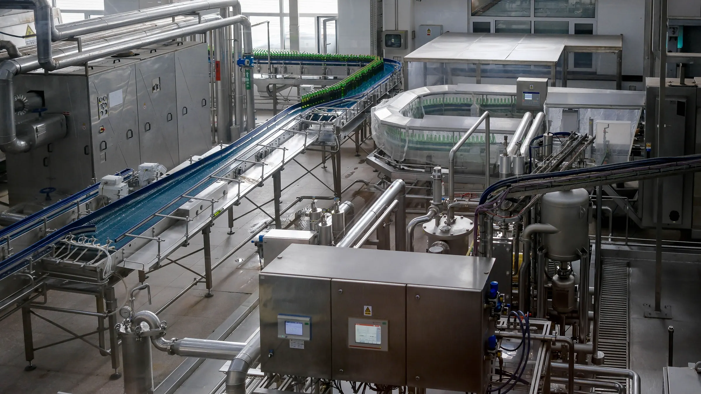 Ligne de conditionnement en inox, bouteilles sur un convoyeur dans une usine