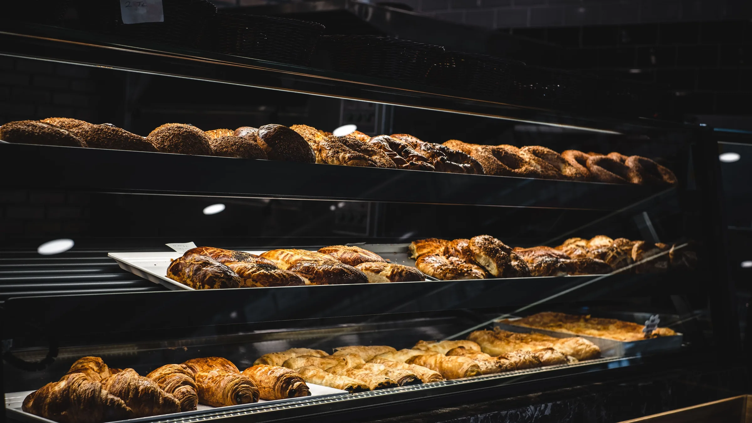 Vitrine de boutique alimentaire, viennoiseries et pains sur des plateaux